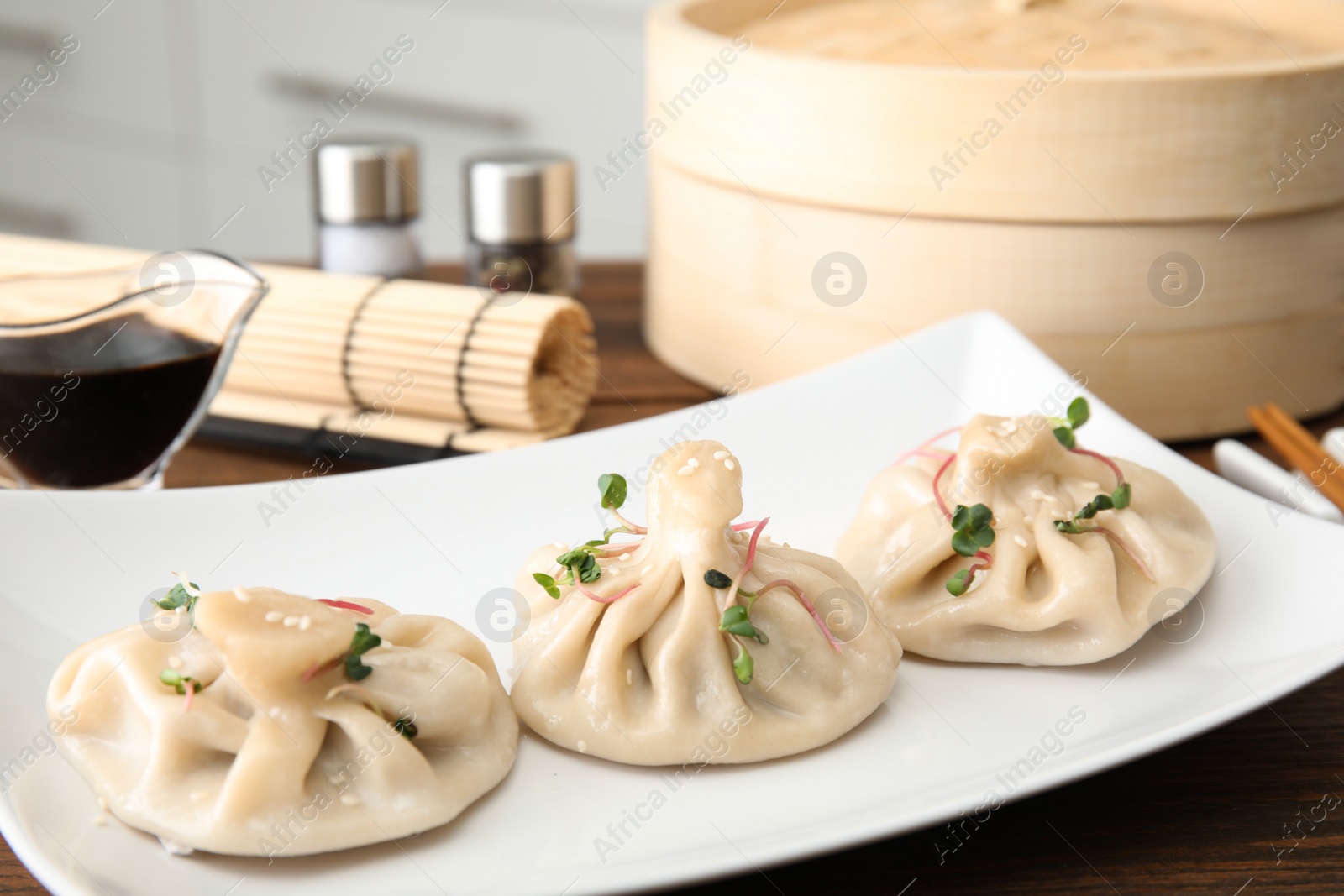 Photo of Plate with tasty baozi dumplings on table, closeup