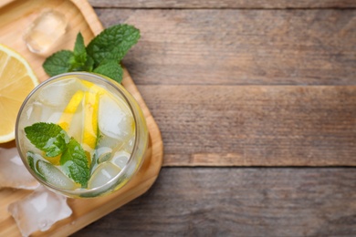 Photo of Delicious lemonade made with soda water and fresh mint on wooden table, top view. Space for text