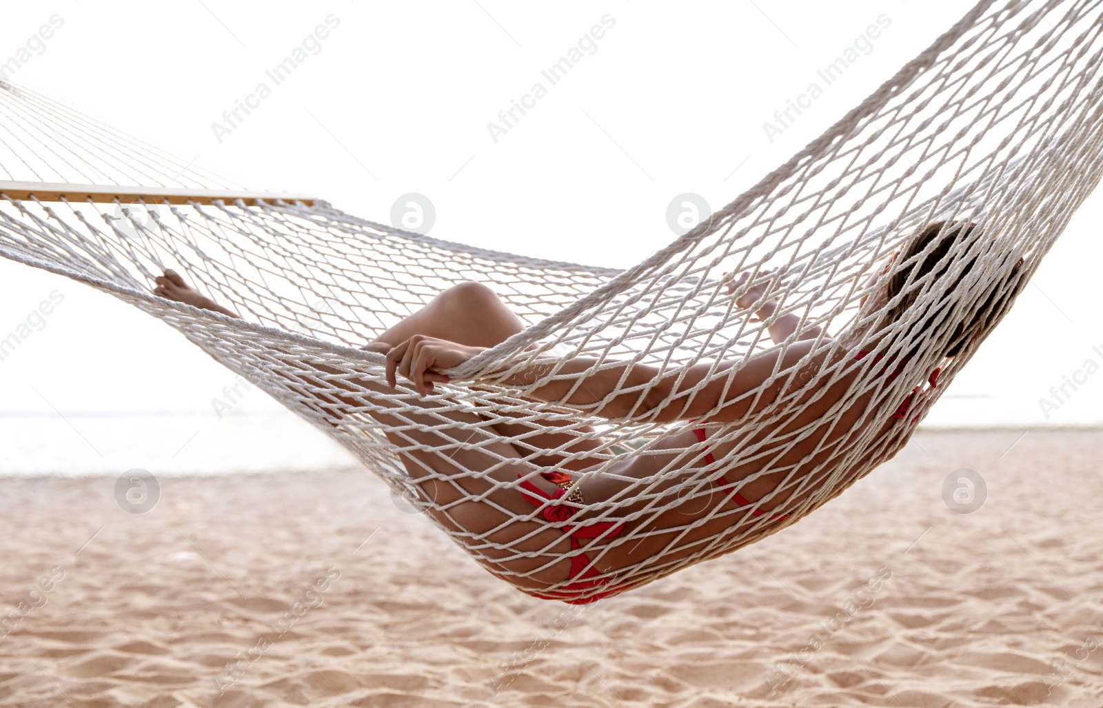 Photo of Young woman relaxing in hammock on beach