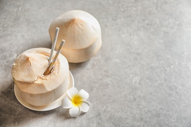 Fresh coconut drink in nut on grey background