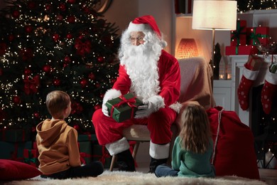 Merry Christmas. Santa Claus giving present to children at home