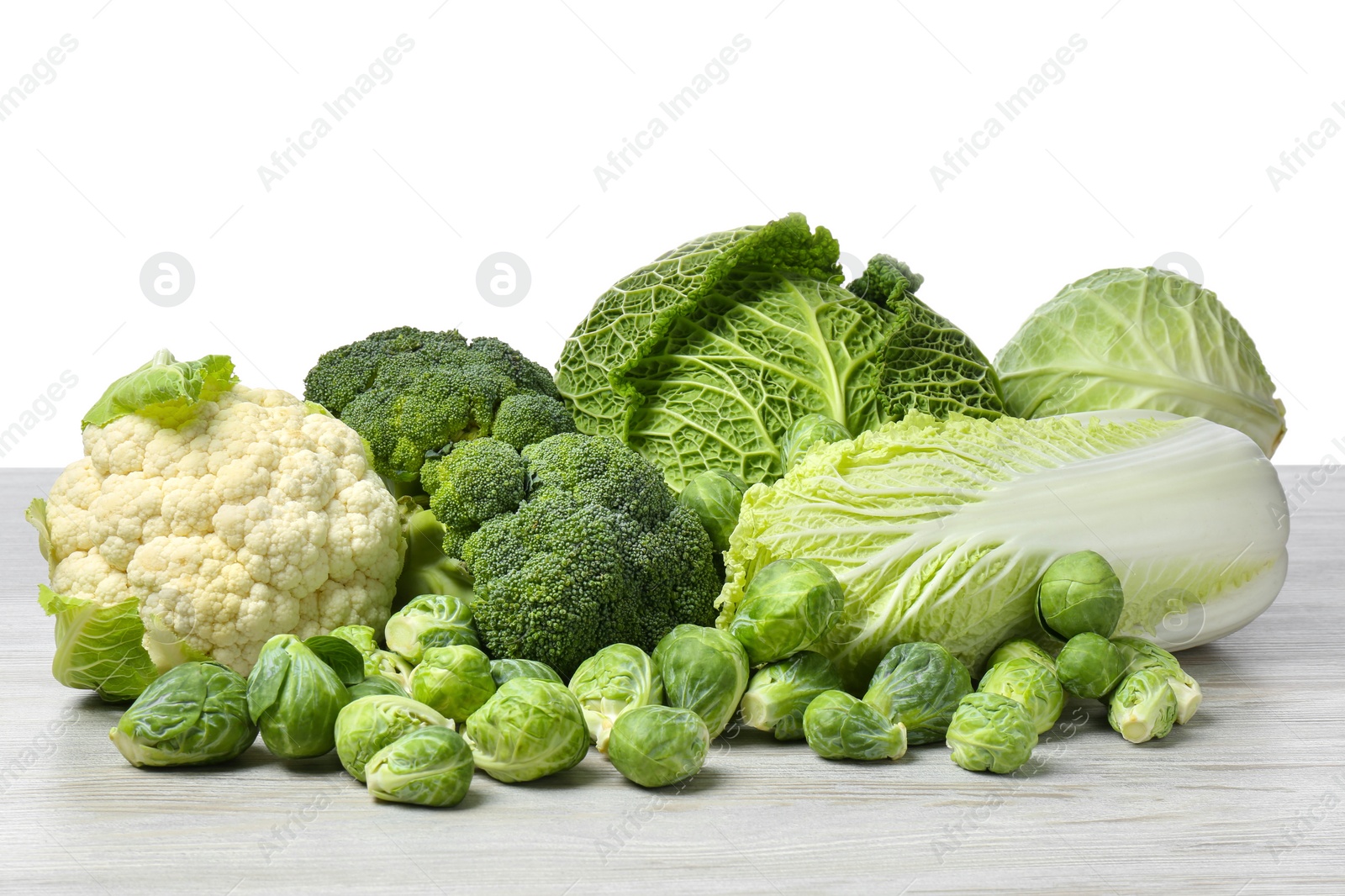 Photo of Many different fresh ripe cabbages on white wooden table