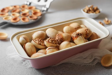 Freshly baked delicious walnut shaped cookies on light grey table, closeup