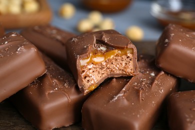 Delicious chocolate candy bars with caramel on table, closeup