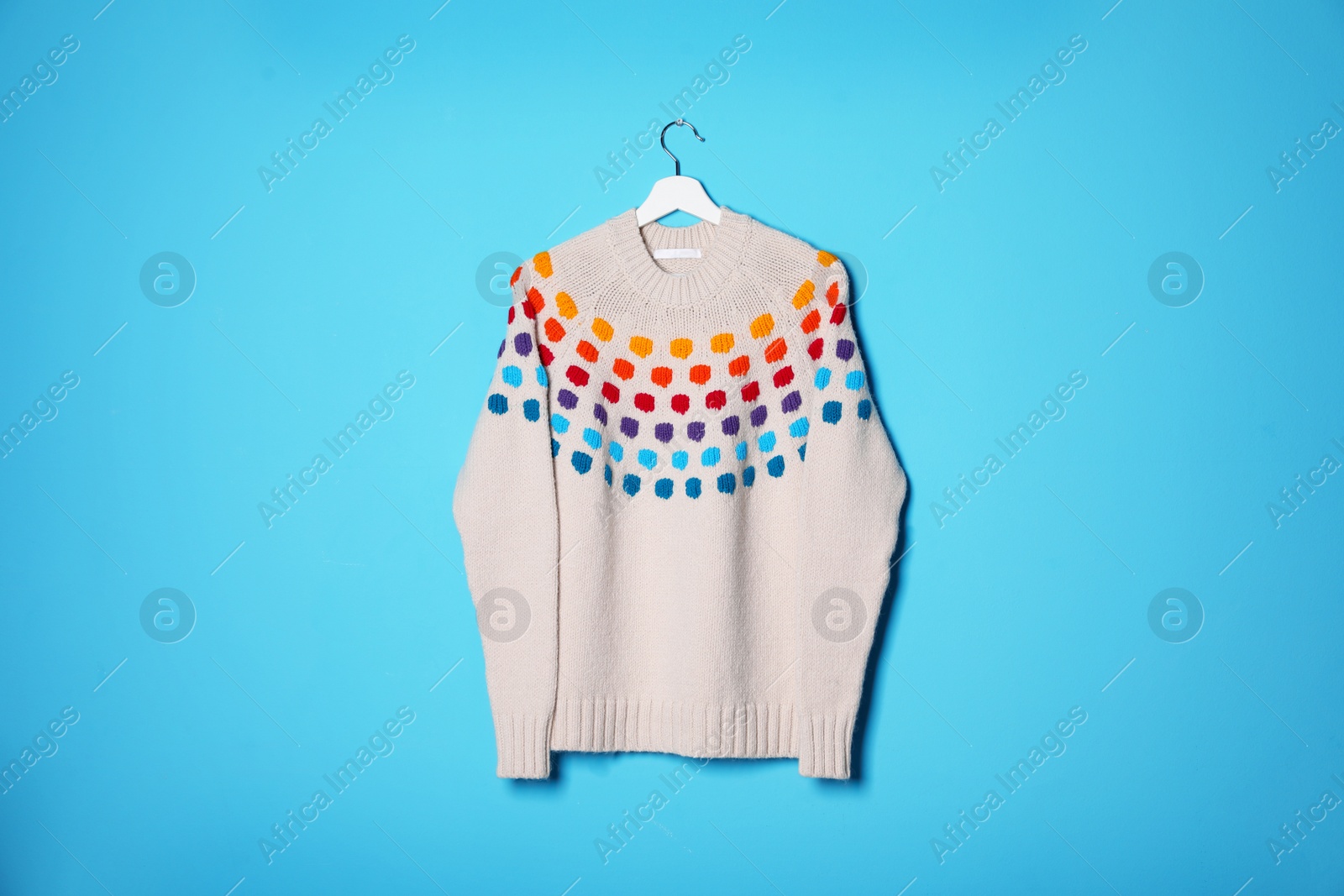 Photo of Hanger with stylish sweater on color background