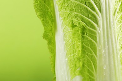 Photo of Fresh ripe Chinese cabbage on light green background, closeup. Space for text