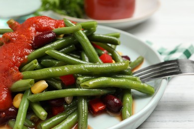 Delicious salad with green beans and tomato sauce served on white wooden table, closeup