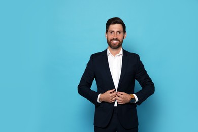 Photo of Portrait of smiling bearded man in suit on light blue background
