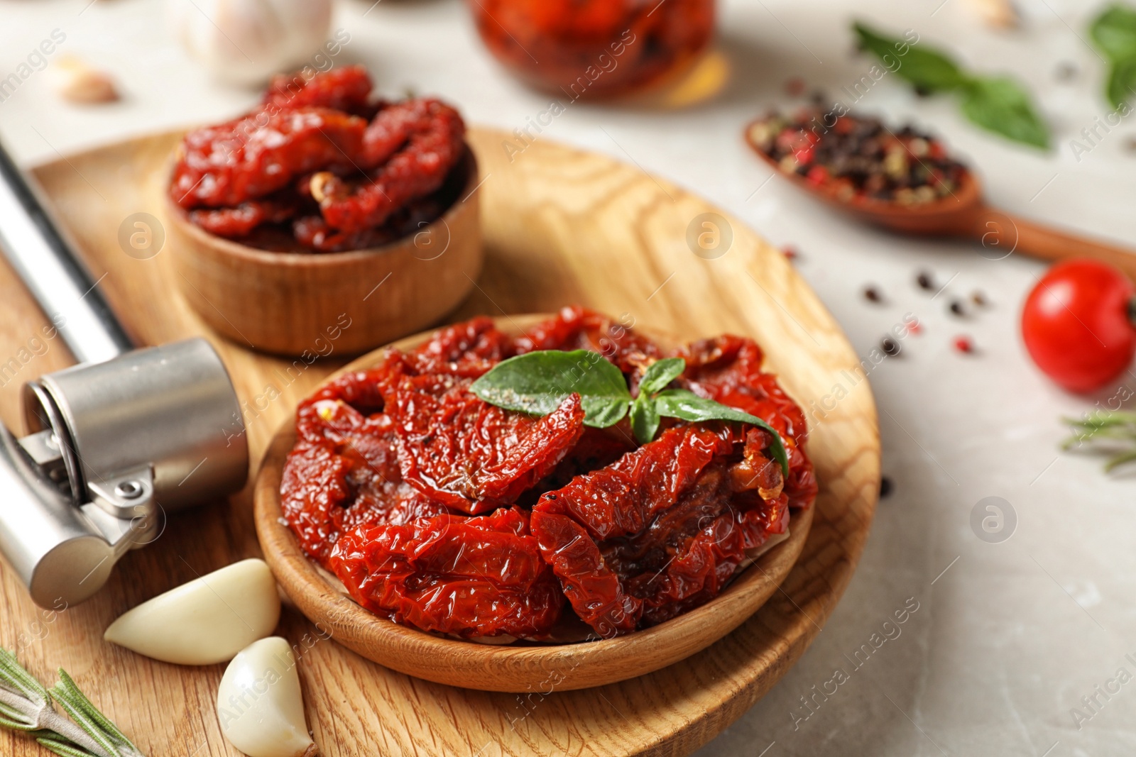 Photo of Plate with dried tomatoes and garlic on table