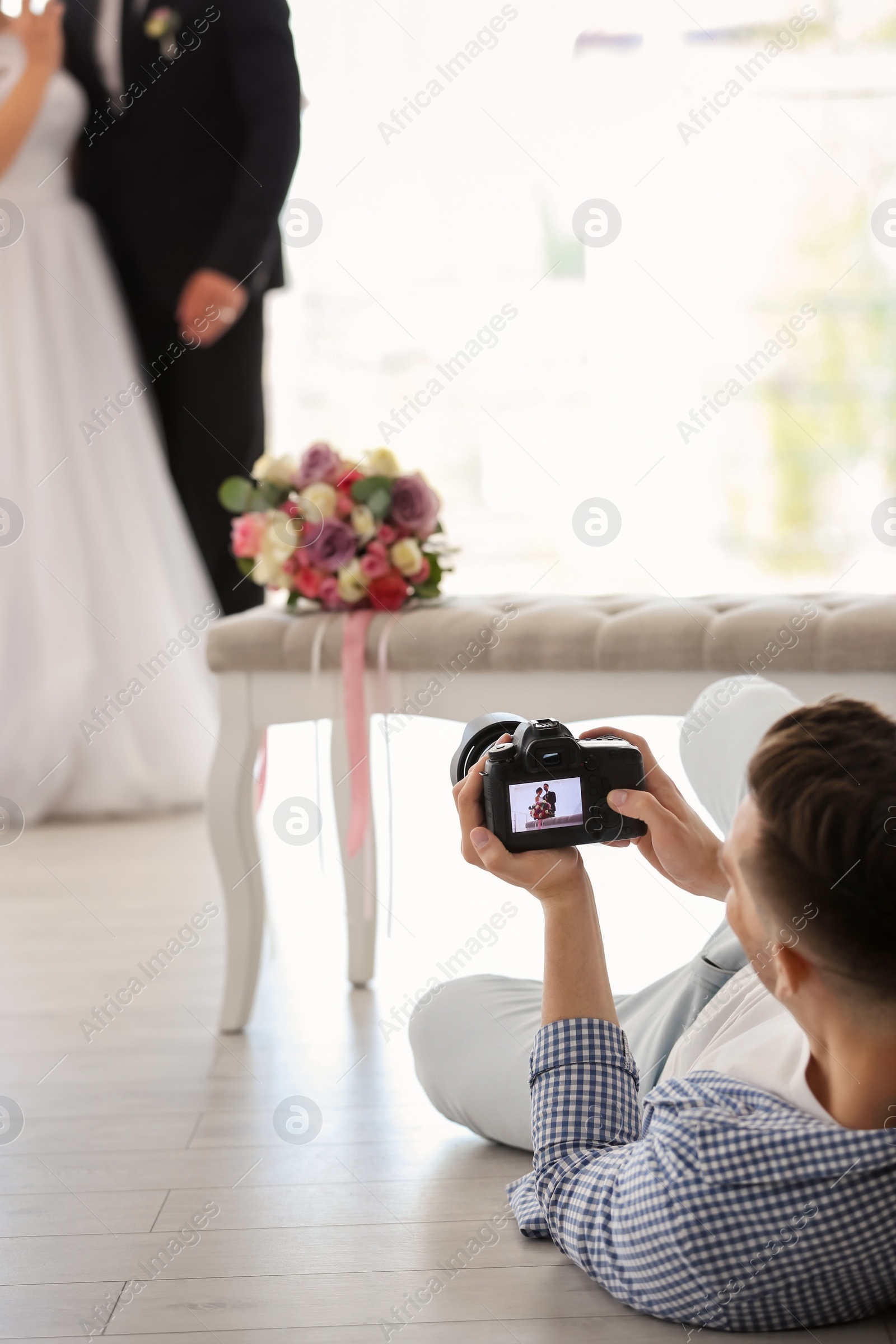 Photo of Professional photographer taking photo of wedding couple in studio