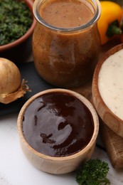 Photo of Fresh marinades and ingredients on white table, closeup