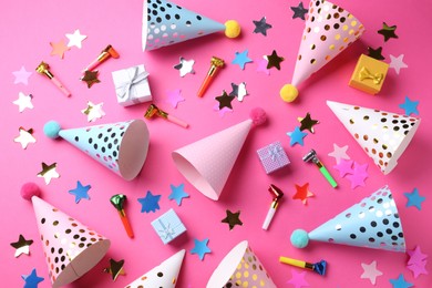 Flat lay composition with party hats on pink background