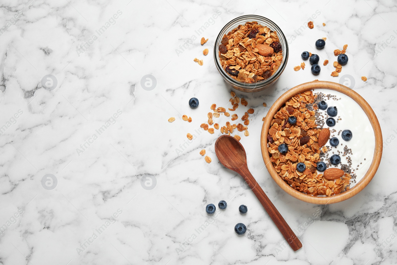 Photo of Tasty homemade granola served on white marble table, flat lay with space for text. Healthy breakfast