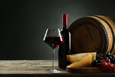 Winemaking. Composition with tasty wine and barrel on wooden table against dark background, space for text