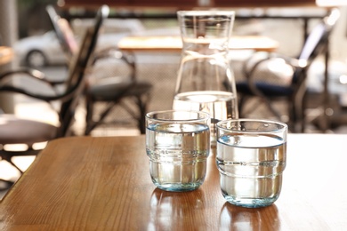 Glassware with water on wooden table indoors