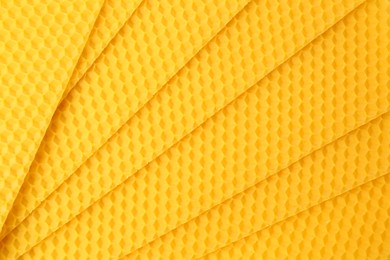 Natural beeswax sheets as background, top view