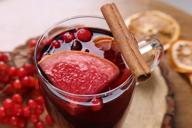 Aromatic mulled wine in glass cup on table, closeup