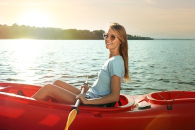 Photo of Happy woman kayaking on river. Summer activity