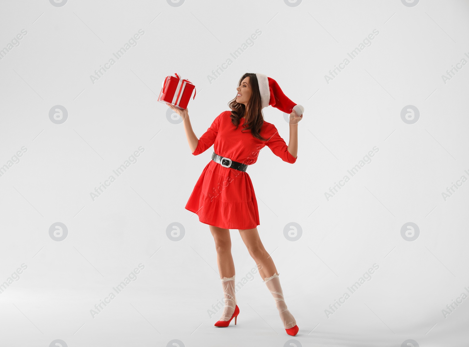 Photo of Beautiful woman wearing Christmas costume with gift on white background