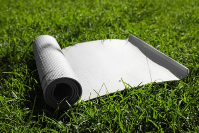 Photo of Karemat or fitness mat on green grass outdoors