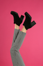 Woman wearing stylish boots on pink background, closeup