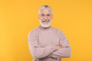 Photo of Portrait of handsome senior man on orange background