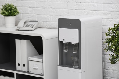 Photo of Modern water cooler in stylish office interior