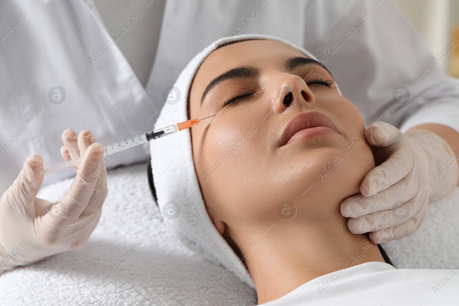 Photo of Doctor giving facial injection to young woman in clinic. Cosmetic surgery