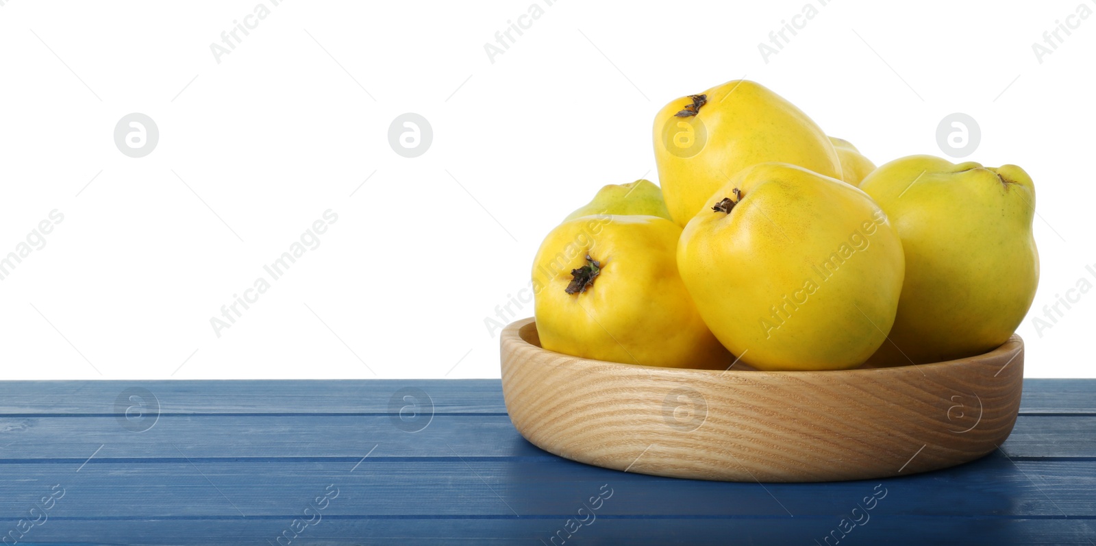 Photo of Delicious fresh ripe quinces on blue wooden table against white background, space for text