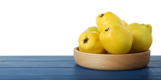 Delicious fresh ripe quinces on blue wooden table against white background, space for text