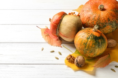 Different pumpkins and space for text on wooden background. Autumn holidays