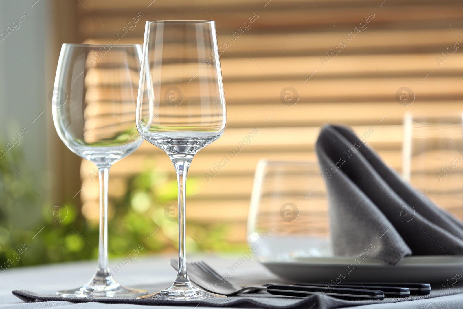 Photo of Table setting with empty wine glasses and napkin