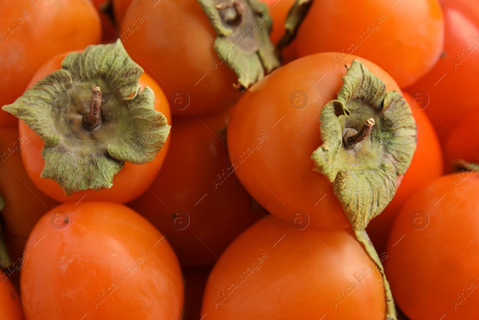 Photo of Tasty fresh ripe persimmons as background, closeup