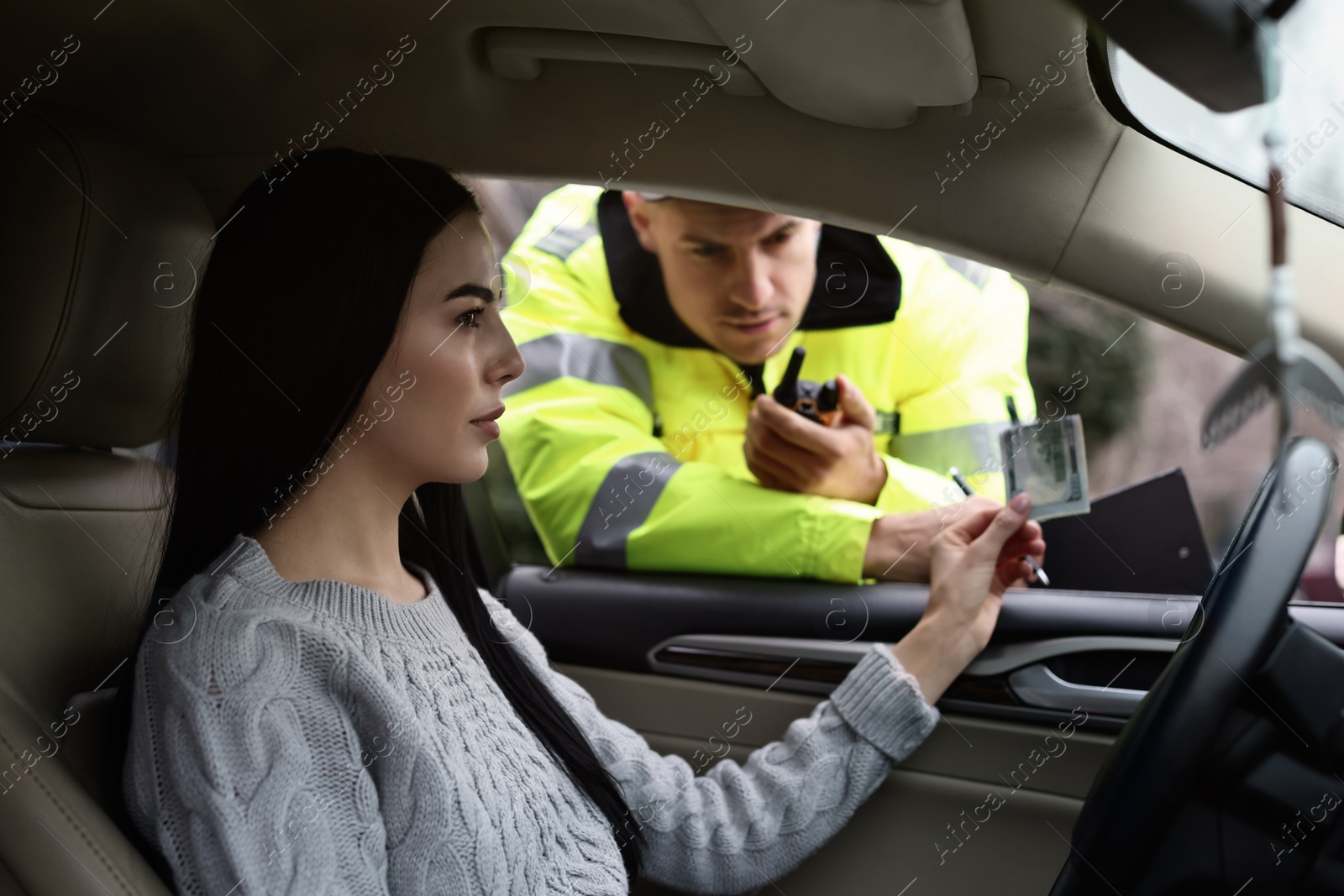 Photo of Woman giving bribe to police officer out of car window