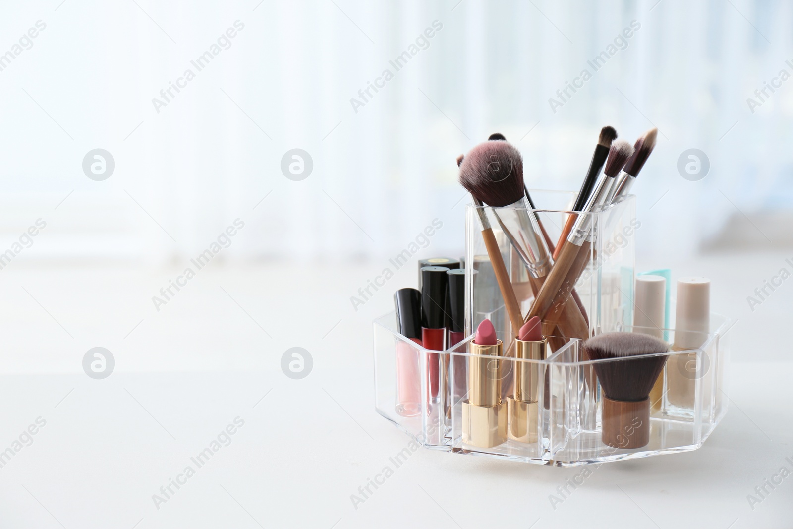 Photo of Organizer with makeup cosmetic products on table indoors. Space for text