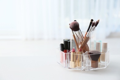 Organizer with makeup cosmetic products on table indoors. Space for text