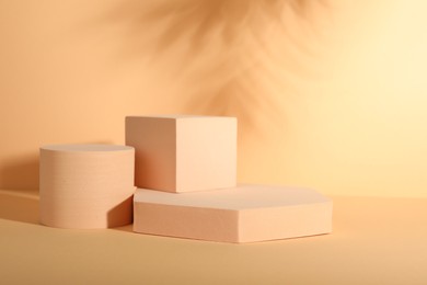 Photo of Presentation of product. Podiums and shadows on orange background. Space for text