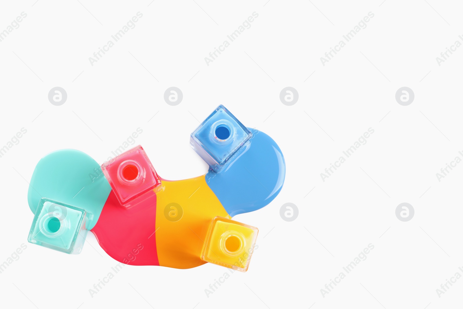 Photo of Spilled different nail polishes with bottles on white background, top view