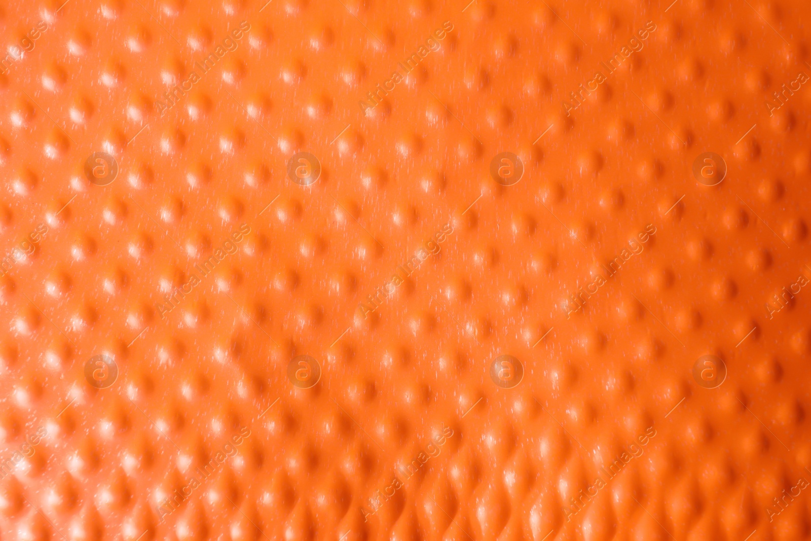 Photo of Texture of orange plastic cup as background, closeup