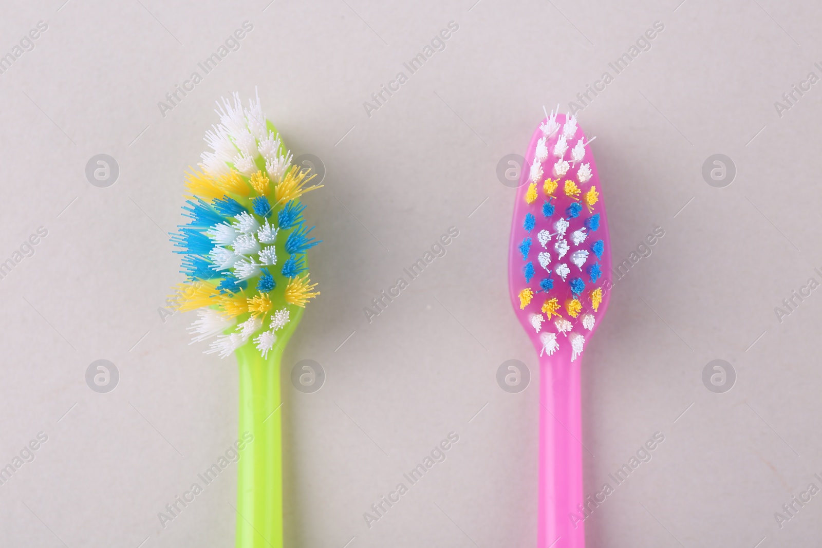 Photo of Colorful plastic toothbrushes on light background, flat lay