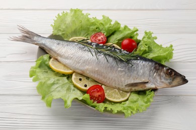 Photo of Delicious salted herring, rosemary, lettuce, tomatoes and lemon on white wooden table