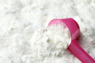 Photo of Powdered infant formula and scoop, closeup with space for text. Baby milk