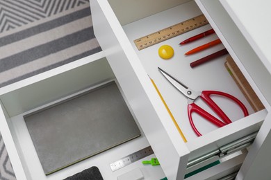 Photo of Office supplies in open desk drawers, above view