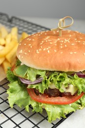 Delicious burger with beef patty and lettuce on white table, closeup