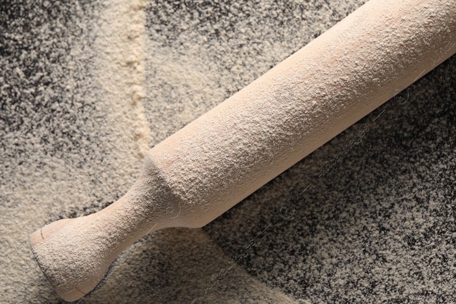 Photo of Flour and rolling pin on table, top view