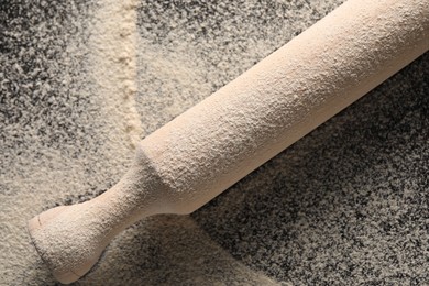 Flour and rolling pin on table, top view