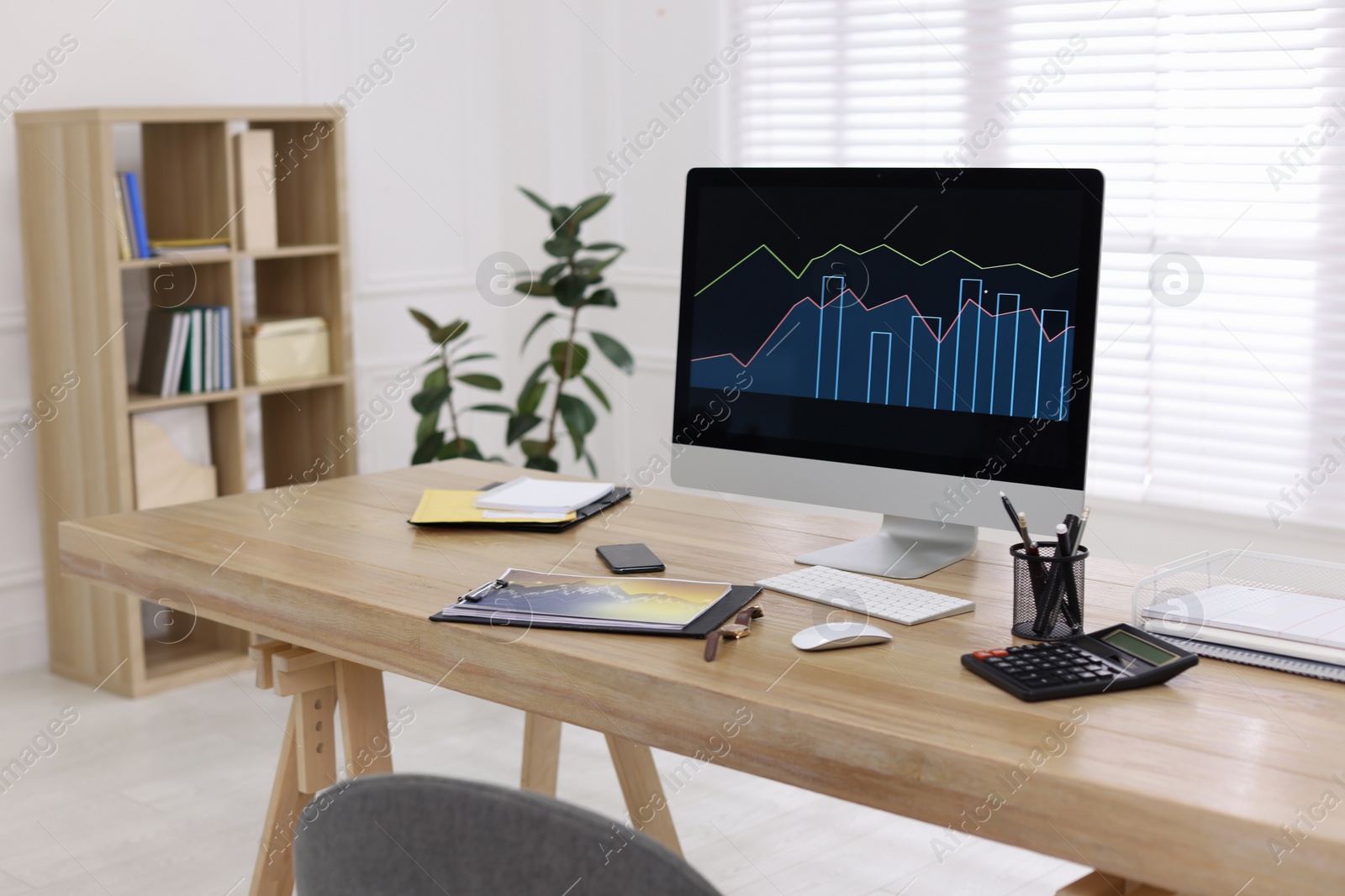 Photo of Workplace with computer and stationery in office. Forex trading