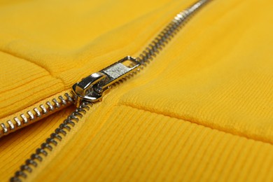 Photo of Yellow sweatshirt with zipper as background, closeup view