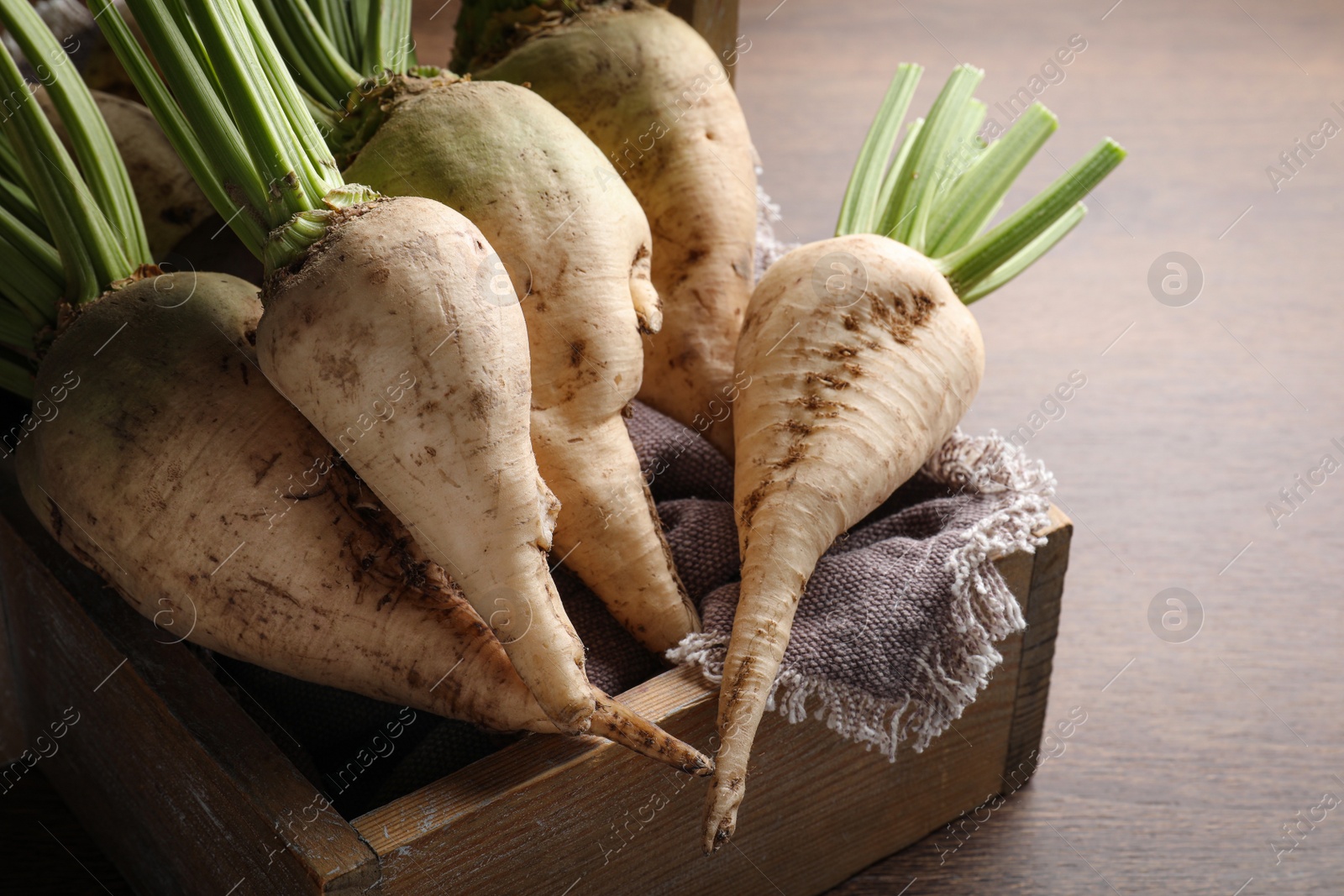 Photo of Basket with fresh sugar beets on wooden table, closeup