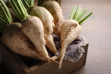 Photo of Basket with fresh sugar beets on wooden table, closeup